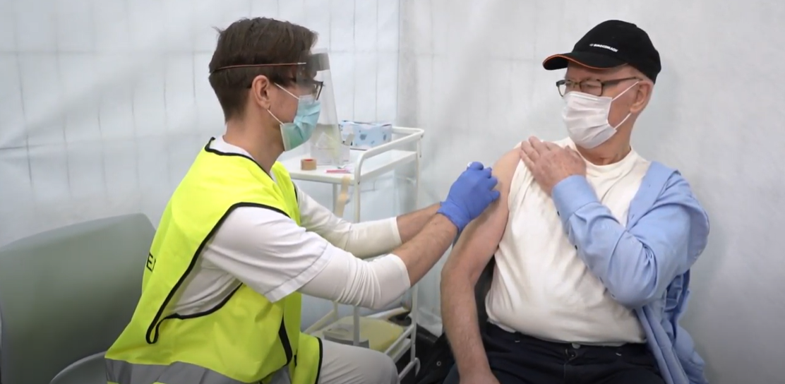 Bilde av en mann som får vaksine. 